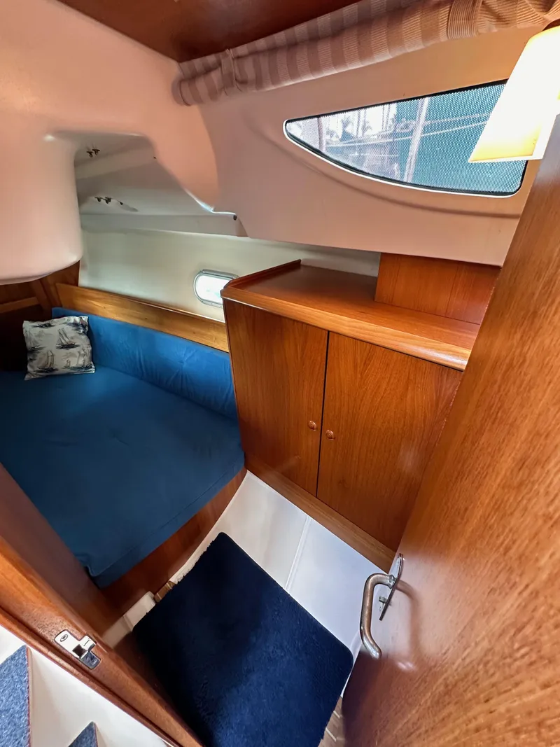Slide: The Image of Cozy cabin interior of 2003 Jeanneau Sun Odyssey 32 sailboat with wooden finish and blue upholstery. - 52