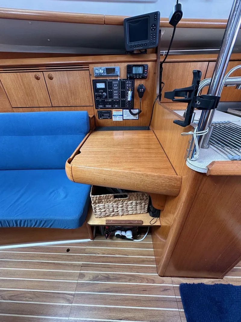 Slide: The Image of Interior of 2003 Jeanneau Sun Odyssey 32 sailboat with navigation equipment and blue seating. - 56