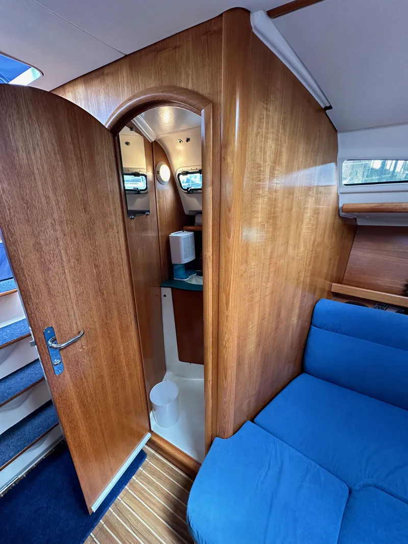 Slide: The Image of Interior of 2003 Jeanneau Sun Odyssey 32 sailboat with wooden finish and blue seating. - 59