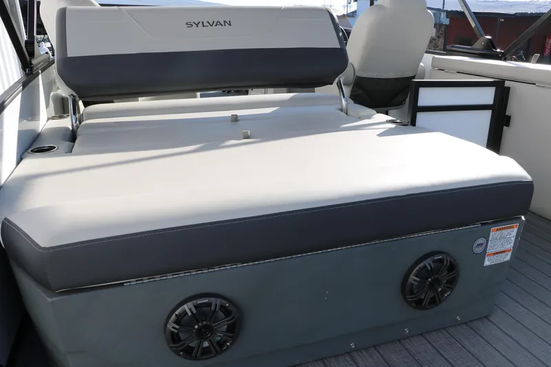 Slide: The Image of 2025 Sylvan Mirage X X1 CLZ DH boat interior with cushioned seating and built-in speakers. - 18