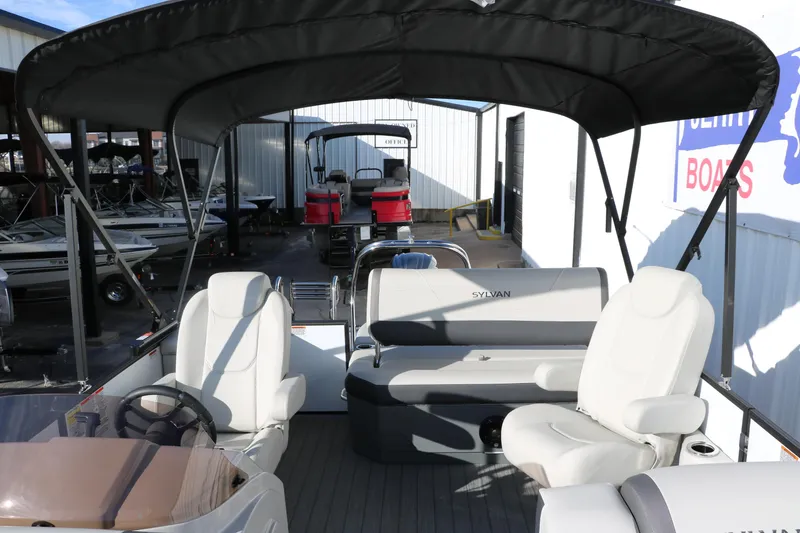 Slide: The Image of 2025 Sylvan Mirage X X1 CLZ DH pontoon boat with canopy and seating, in a showroom. - 22