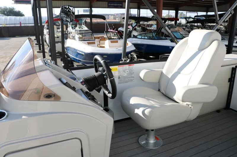 Slide: The Image of 2025 Sylvan Mirage X X1 CLZ DH boat interior with captain's chair and steering console. - 24
