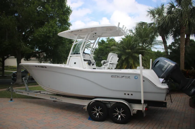 The Image of 2023 Sea Fox 228 boat on trailer, parked outdoors with trees in background. - 1