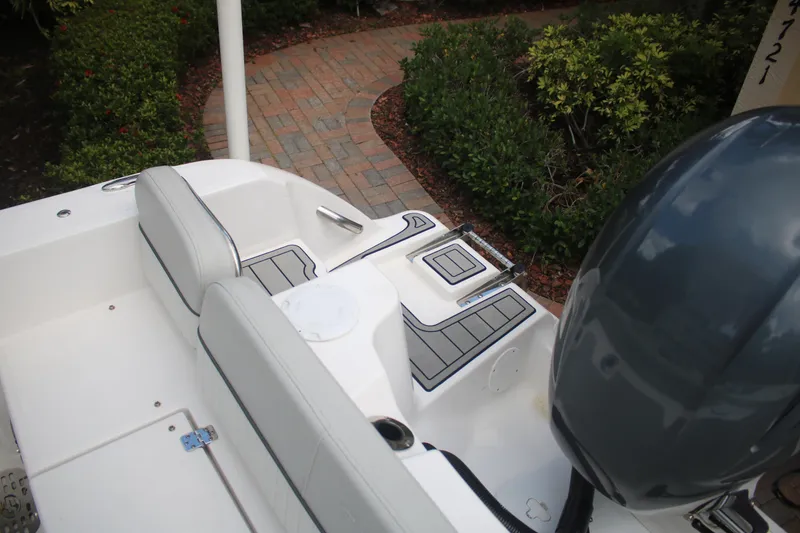 Slide: The Image of 2023 Sea Fox 228 boat interior with seating and motor, surrounded by greenery. - 20