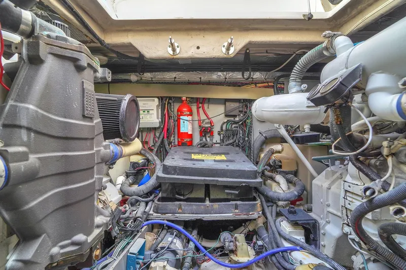 Slide: The Image of Engine room of 2004 Sea Ray 460 Sundancer with visible machinery and fire extinguisher. - 33
