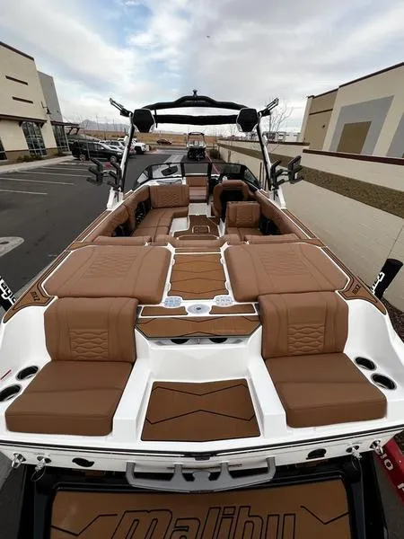 Slide: The Image of 2025 Malibu 24 MXZ boat with luxurious brown seating and sleek design. - 10