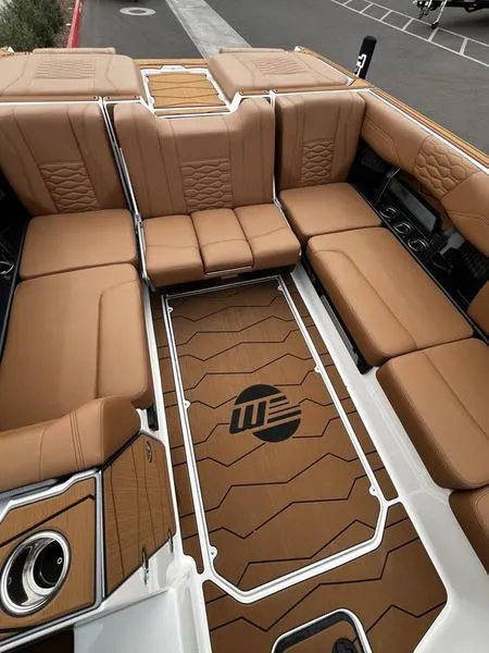 Slide: The Image of 2025 Malibu 24 MXZ boat interior with luxurious brown seating and stylish flooring. - 16