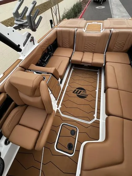 Slide: The Image of Luxurious interior of 2025 Malibu 24 MXZ boat with tan leather seating and stylish flooring. - 18