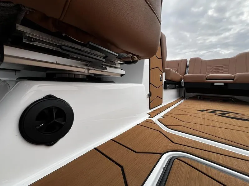 Slide: The Image of 2025 Malibu 24 MXZ interior with brown seating and sleek flooring design. - 19