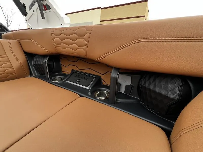 Slide: The Image of 2025 Malibu 24 MXZ interior with tan leather seats and built-in speakers. - 21
