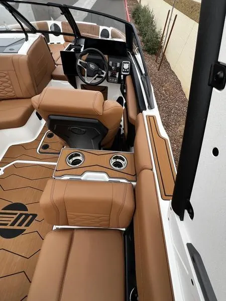 Slide: The Image of 2025 Malibu 24 MXZ boat interior with tan leather seats and modern dashboard. - 22