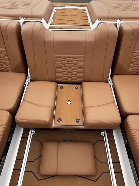 Slide: The Image of 2025 Malibu 24 MXZ boat interior with tan leather seating and wood accents. - 24