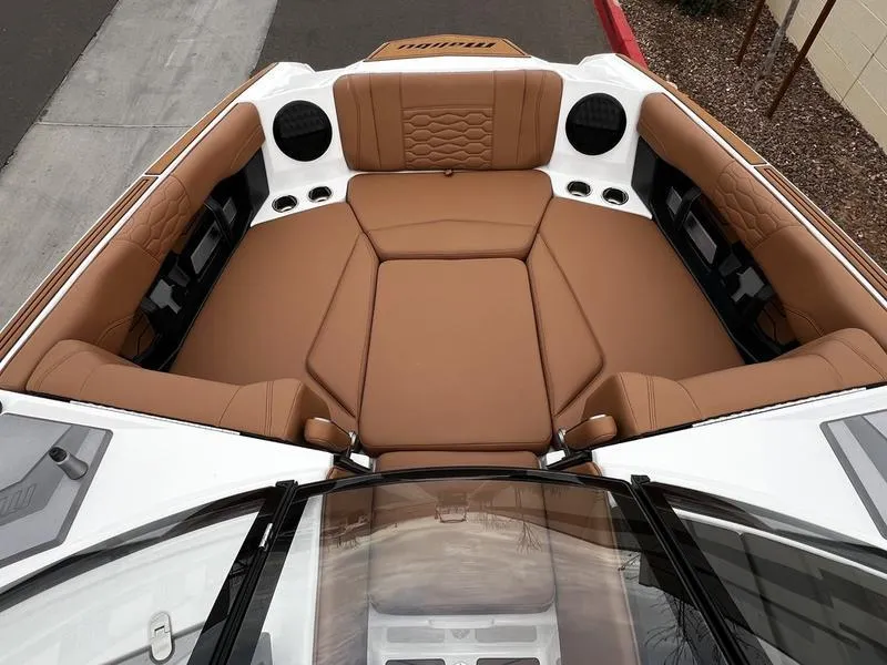 Slide: The Image of 2025 Malibu 24 MXZ boat interior with luxurious brown seating and modern design. - 25
