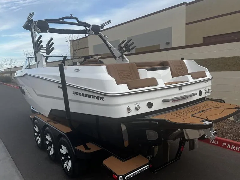 Slide: The Image of 2025 Malibu 24 MXZ boat on trailer, featuring sleek design and modern wakeboard tower. - 3