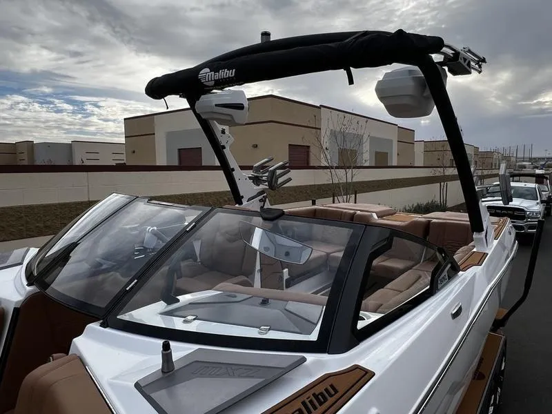 Slide: The Image of 2025 Malibu 24 MXZ boat with sleek design and modern features, docked outdoors. - 6