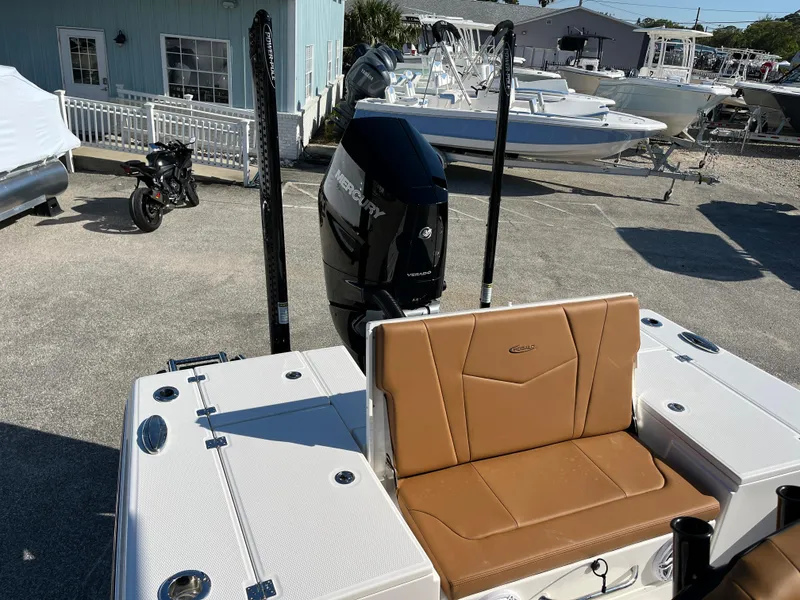 Slide: The Image of 2025 Robalo 246 Cayman boat with tan seating and powerful outboard motor in a marina setting. - 7