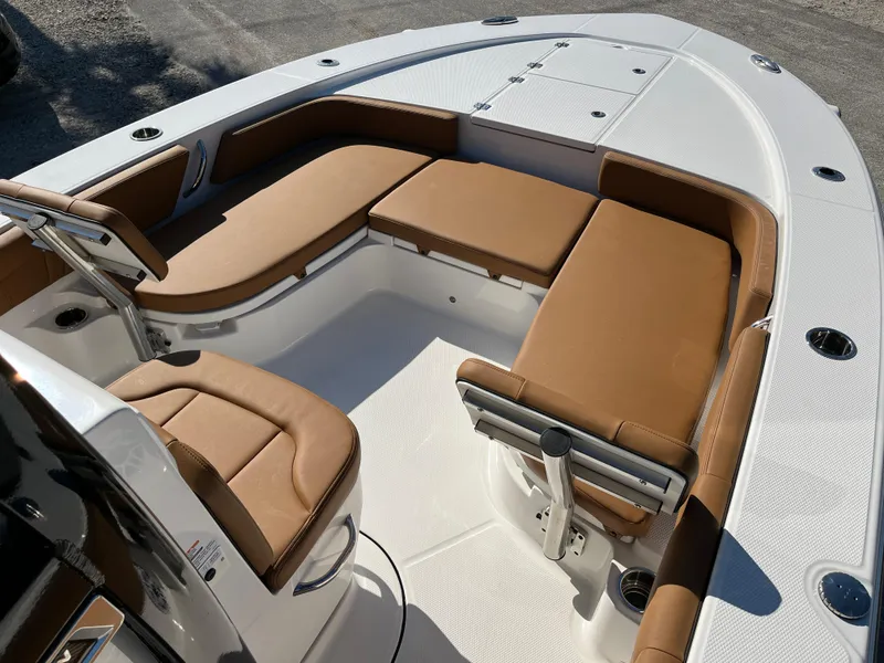 Slide: The Image of 2025 Robalo 246 Cayman boat interior with tan seating and white deck. - 9