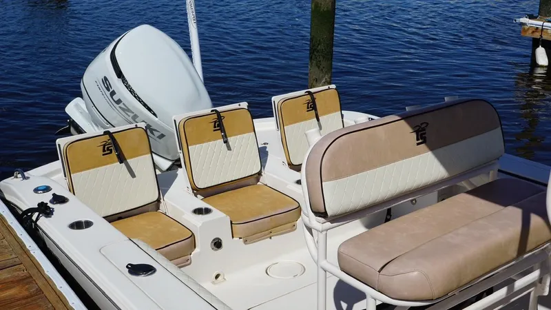 Slide: The Image of 2023 Carolina Skiff 24 Ultra Elite boat with seating and Suzuki outboard motor. - 2