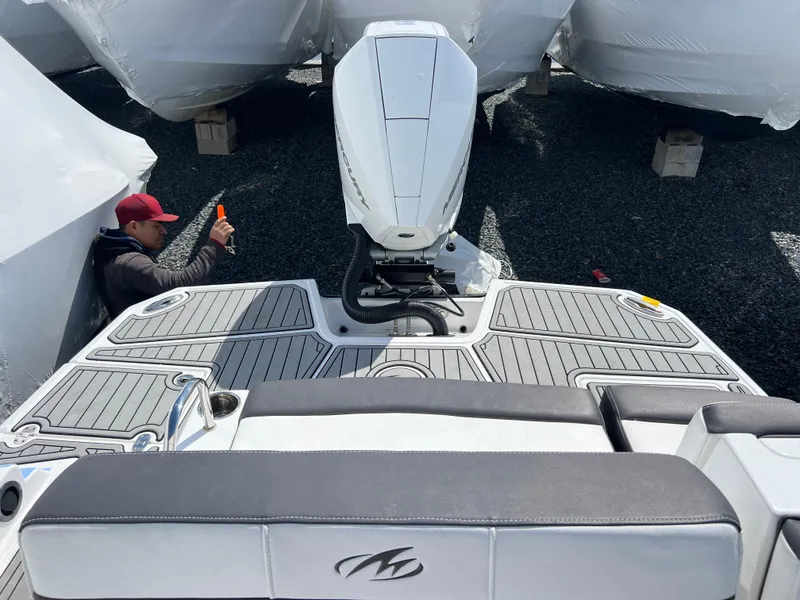 Slide: The Image of 2022 Monterey M65 boat with outboard motor, viewed from the deck, person working nearby. - 20