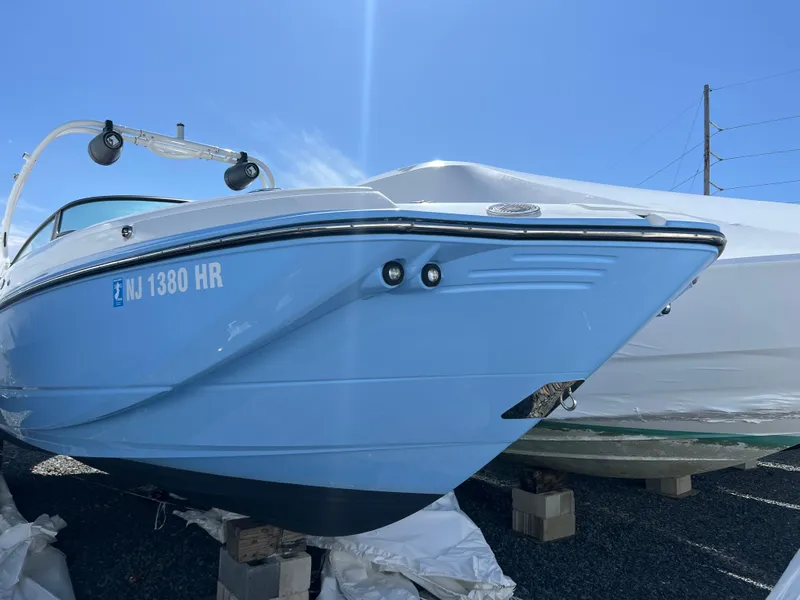 Slide: The Image of 2022 Monterey M65 boat in light blue, docked on blocks under clear sky. - 4