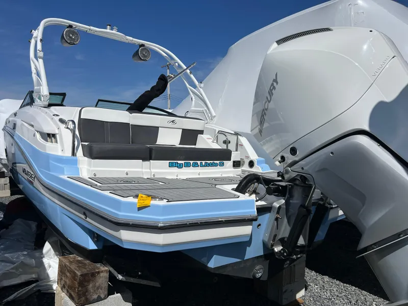 Slide: The Image of 2022 Monterey M65 boat with Mercury engine, docked on gravel, under clear blue sky. - 6