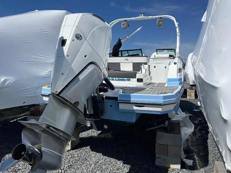Slide: The Image of 2022 Monterey M65 boat with powerful outboard motor, docked on gravel, under clear blue sky. - 8