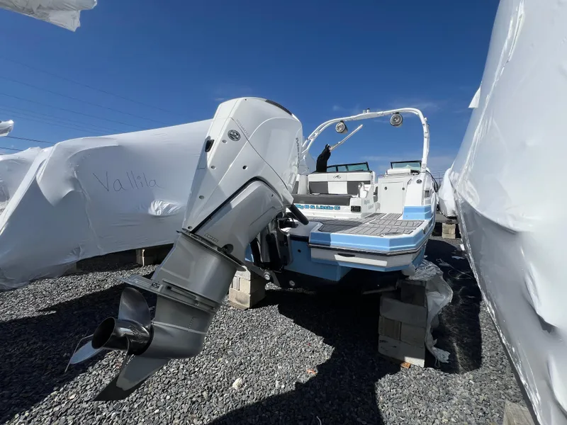 Slide: The Image of 2022 Monterey M65 boat with outboard motor, displayed outdoors under clear blue sky. - 9