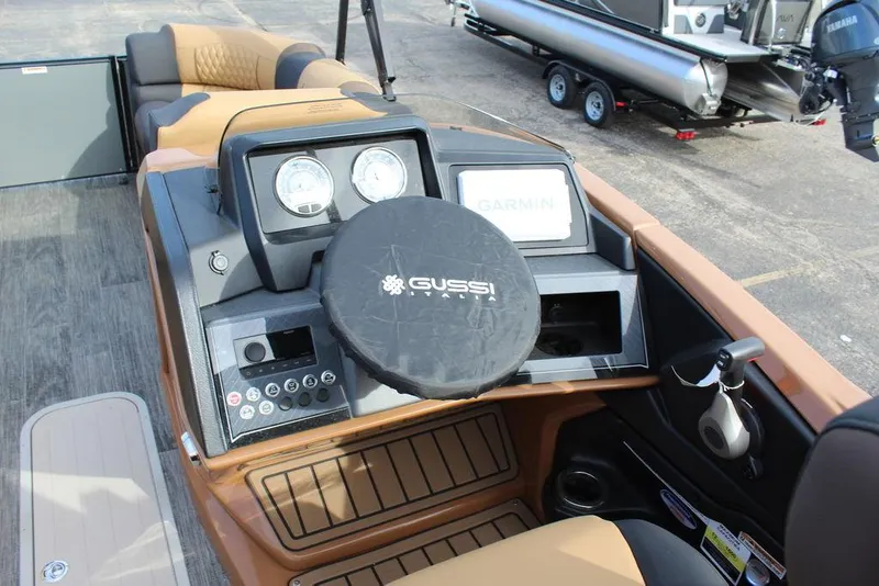 Slide: The Image of 2025 Avalon Catalina Versatile Rear Bench 23 FT boat dashboard with Gussi steering wheel and Garmin display. - 18