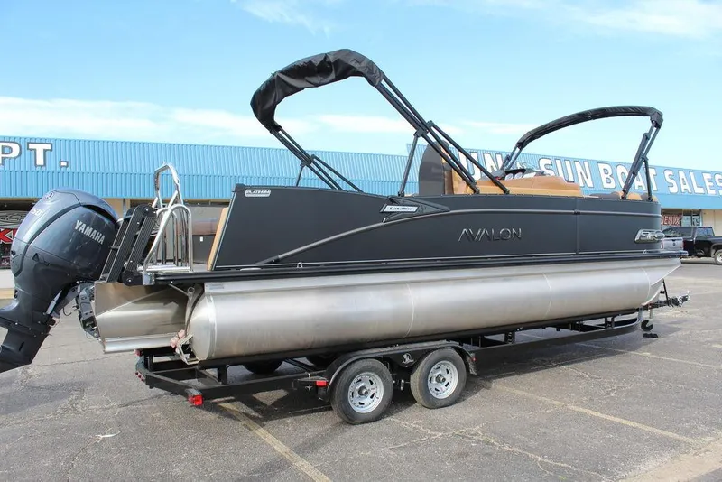 Slide: The Image of 2025 Avalon Catalina Versatile Rear Bench 23 FT pontoon boat on trailer, parked outdoors. - 3