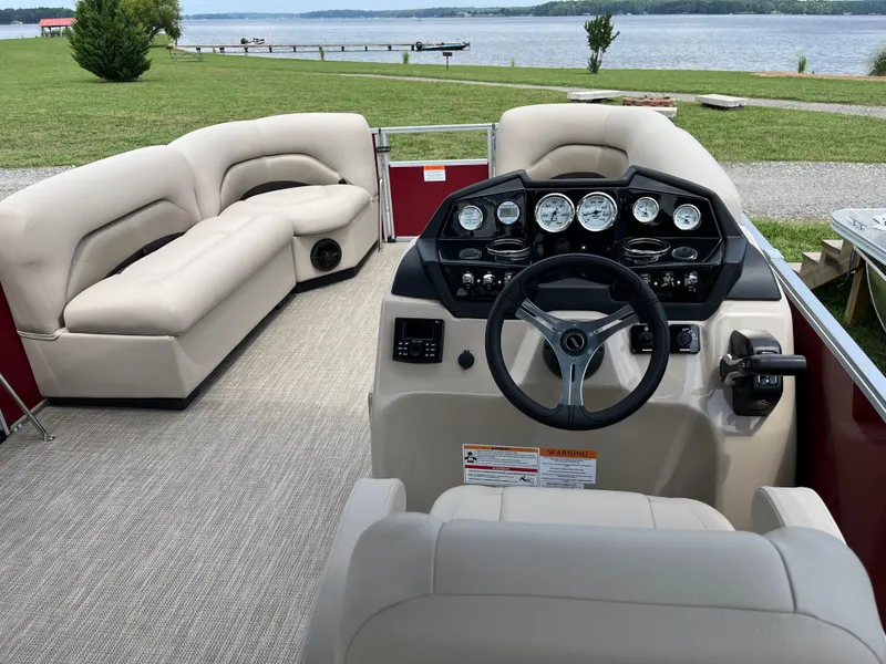 Slide: The Image of 2024 Landau Island Breeze 232 Cruise pontoon boat interior with plush seating and control panel. - 12