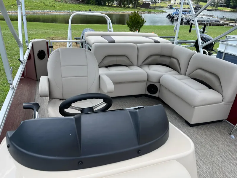 Slide: The Image of 2024 Landau Island Breeze 232 Cruise pontoon boat interior with plush seating and steering console. - 15
