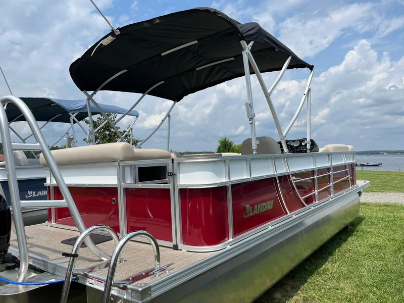 Slide: The Image of 2024 Landau Island Breeze 232 Cruise pontoon boat with red exterior and black canopy. - 3