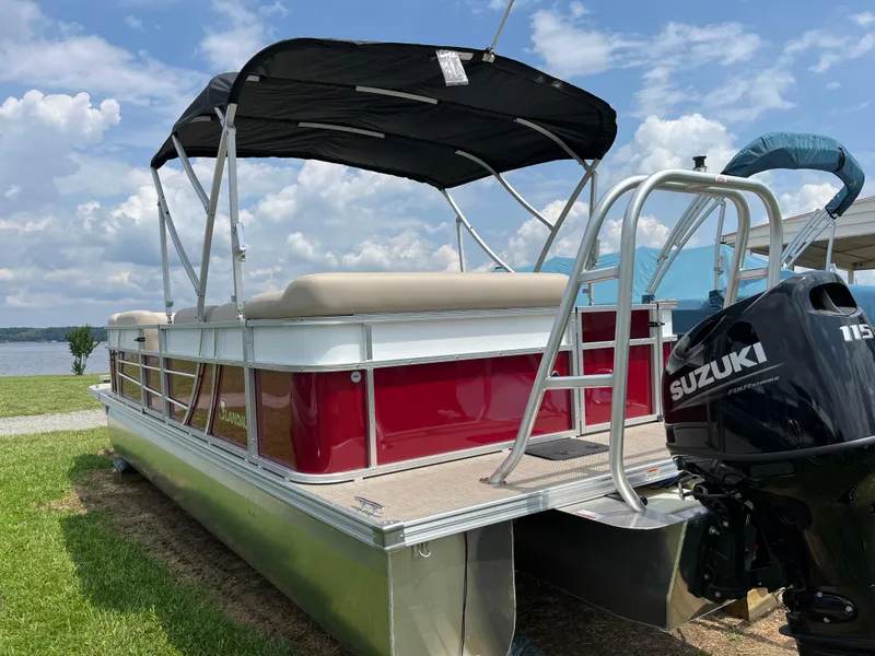 Slide: The Image of 2024 Landau Island Breeze 232 Cruise pontoon boat with Suzuki engine, docked on grass. - 4