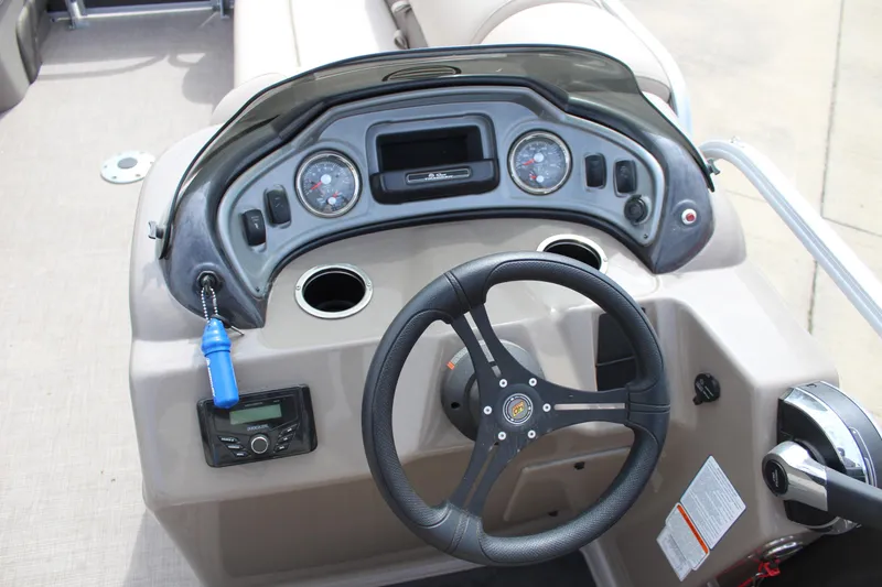 Slide: The Image of 2023 Sun Tracker Party Barge 22 DLX dashboard with steering wheel and control panel. - 13
