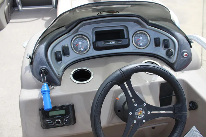 Slide: The Image of 2023 Sun Tracker Party Barge 22 DLX dashboard with steering wheel and control panel. - 14