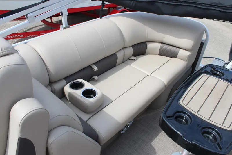 Slide: The Image of 2023 Sun Tracker Party Barge 22 DLX interior with beige seating and cup holders. - 15