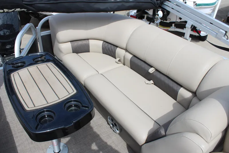 Slide: The Image of 2023 Sun Tracker Party Barge 22 DLX interior with beige seating and table. - 16