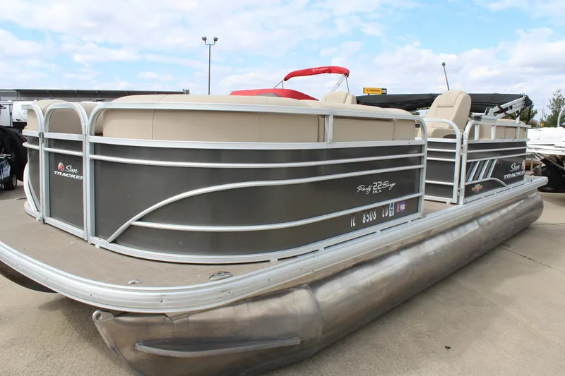 Slide: The Image of 2023 Sun Tracker Party Barge 22 DLX pontoon boat on display outdoors. - 2