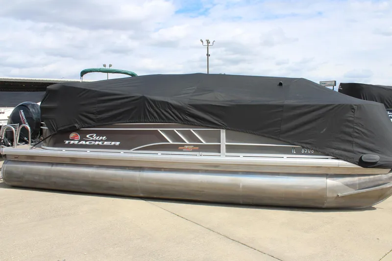 Slide: The Image of 2023 Sun Tracker Party Barge 22 DLX pontoon boat covered, parked on concrete. - 23