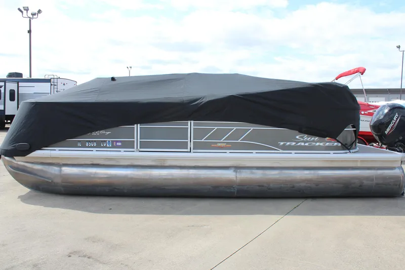 Slide: The Image of 2023 Sun Tracker Party Barge 22 DLX pontoon boat with cover, parked on concrete. - 25