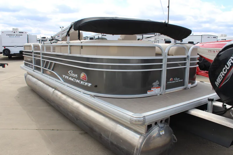 Slide: The Image of 2023 Sun Tracker Party Barge 22 DLX pontoon boat with canopy, docked outdoors. - 4