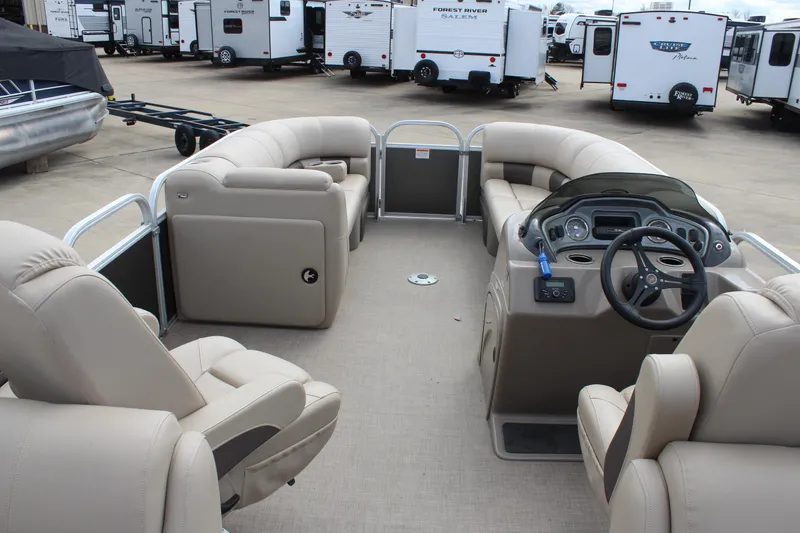 Slide: The Image of 2023 Sun Tracker Party Barge 22 DLX interior with beige seating and steering console. - 7