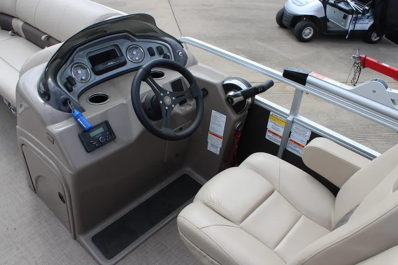 Slide: The Image of 2023 Sun Tracker Party Barge 22 DLX helm with beige seating and control panel. - 8