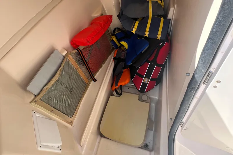Slide: The Image of Storage compartment in a 2007 Grady-White Tournament 275 boat with life jackets and gear. - 19