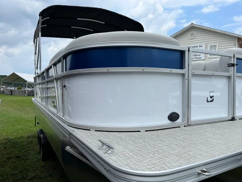 Slide: The Image of 2024 Landau Island Breeze 232 Cruise pontoon boat with canopy, docked on grass. - 16