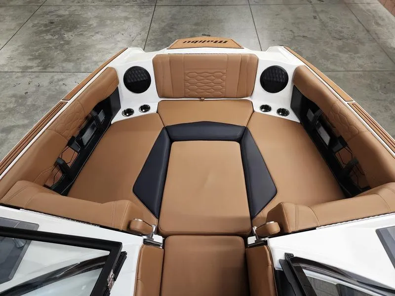 Slide: The Image of 2025 Malibu 24 MXZ boat interior with tan and black seating, modern design. - 10