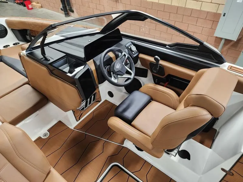 Slide: The Image of 2025 Malibu 24 MXZ boat interior with tan leather seats and modern dashboard. - 11