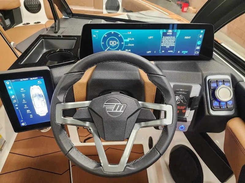 Slide: The Image of 2025 Malibu 24 MXZ boat dashboard with digital displays and modern steering wheel. - 13