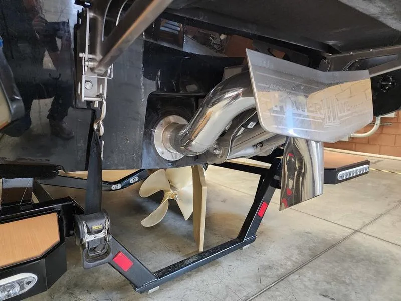 Slide: The Image of 2025 Malibu 24 MXZ boat's rear view showing propeller and exhaust system. - 22