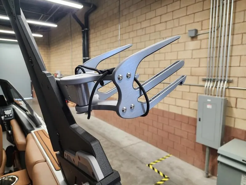 Slide: The Image of 2025 Malibu 24 MXZ boat with a sleek wakeboard rack in an industrial setting. - 26